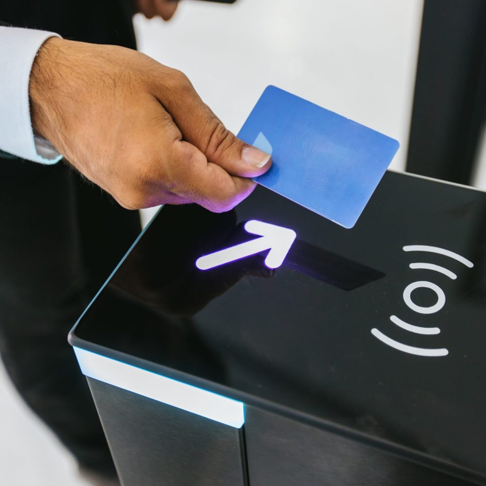 Businessman using card to open automatic gate machine in office building. Male using smart card to open automatic gate machine in office building. Working routine concept.